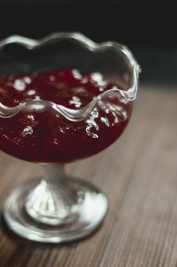 Baharatlı cam servis kasesinde kızılcık sosu. Bayram yemeği ya da özel bir gün için hazırlanmış şenlikli ve tatlı yiyecekler.