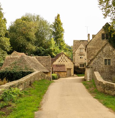 Cotswolds 'da geleneksel bir İngiliz köyü olan Arlington Row, Bibury' deki büyüleyici taş kulübeler ve tarihi köprü.