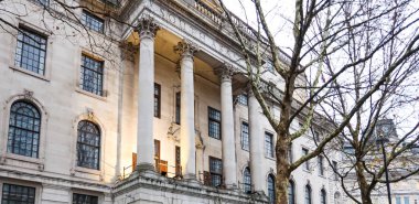 Londra 'daki tarihi Güney Afrika Evi cephesinde güçlü klasik mimari, uzun sütunlar ve çıplak ağaç dalları aracılığıyla süslenmiş ayrıntılar yer alıyor.