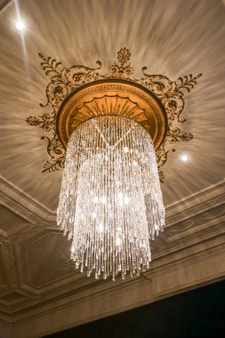 Zarif kristal avize dekore edilmiş bir tavandan ışıl ışıl parlıyor, ışığı yansıtıyor ve yıldız patlaması desenleri yaratıyor, lüksü ve refahı taşıyor.