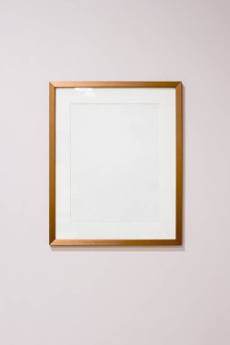 Işık duvarında paspas olan boş ahşap çerçeve, sanat eseri, metin veya reklam için çok yönlü kopya alanı sağlıyor