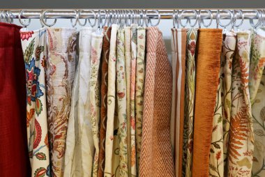 Çeşitli desenleri ve dokuları gösteren dekoratif kumaş örnekleri, perde, döşeme ve ev dekorasyonu projeleri için seçenekler sunar
