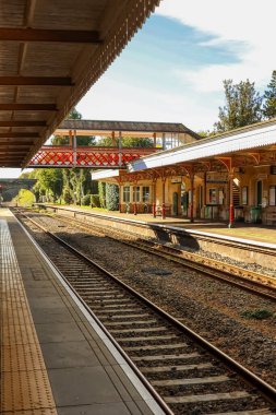 Klasik mimarisi olan tarihi tren istasyonu platformları ve rayları yolcuları bekliyor. Kemble tren istasyonu, Gloucestershire, İngiltere