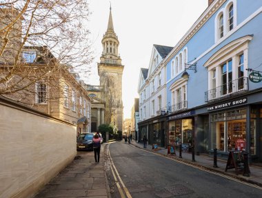 Oxford, İngiltere, İngiltere 19 Aralık 2025: Tarihi Turl Caddesi boyunca yürüyen yayalar, Oxford 'daki All Saints Kilisesi ve dükkan cephelerini gösteriyor