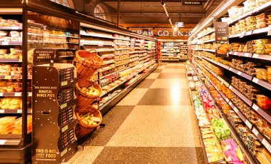 Londra, İngiltere, İngiltere 19 Aralık 2025: Uygun paketlenmiş yemekler ve taze gıda seçenekleriyle dolu yoğun bir süpermarket koridoru