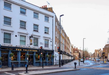 Londra, İngiltere, 19 Aralık 2025: The Volunteer pub, klasik İngiliz binası ve işlek şehir kavşağının yer aldığı Londra sokak manzarası