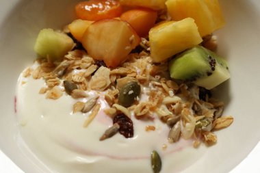 Sağlıklı kahvaltılık yoğurt kasesi tahıl, tohum ve besleyici bir yemek için doğranmış taze meyveyi birleştiriyor. Cotswold kırsal, İngiltere