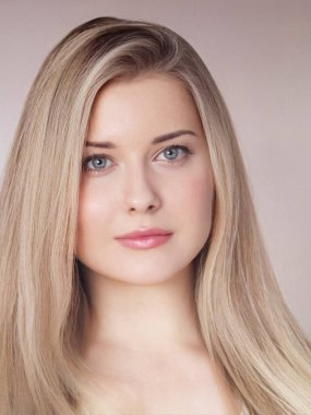 Genç sarışın kadın doğal bir güzellik portresi için poz veriyor. Sağlıklı cilt, uzun düz saç ve açık mavi gözler.