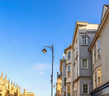 Klasik bir sokak lambası ve mavi gökyüzünün altındaki tarihi bir binanın parçalarıyla geleneksel mimarinin yer aldığı Oxford caddesi cephesi.