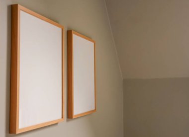 Tarafsız bir bej duvardaki boş ahşap çerçeveler modeller ve modern iç mekan sunumları için minimalist dekor ve geniş kopya alanı oluşturuyor.