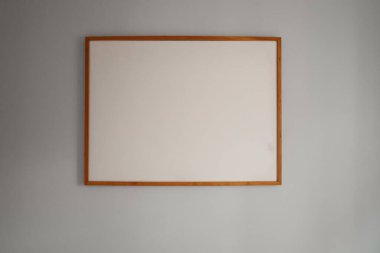 Boş beyaz bir tuval ile dikdörtgen ahşap çerçeve, sanat veya reklam için mükemmel nötr gri arka plan ile maket