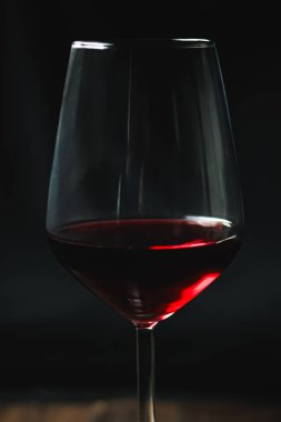 Temiz bir bardağı dolduran kırmızı şarap, zengin renkler ve zarif yansımalar gösteriyor. Kutlama, güzel yemekler ve rahatlama.
