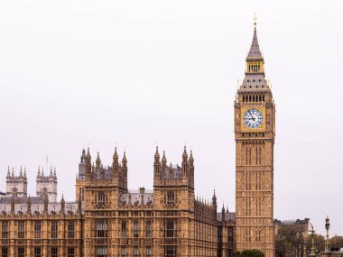 Elizabeth Kulesi, aynı zamanda Big Ben olarak da bilinir, Londra, İngiltere 'deki Parlamento binalarının üzerinde, parlak bir gökyüzünün altında, Gotik mimariyi gözler önüne seren,