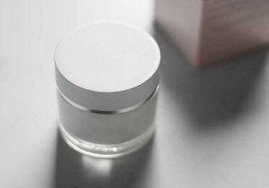 Sleek white and silver cosmetic cream jar showcased on a bright background, exuding elegance and promoting a fresh beauty aesthetic