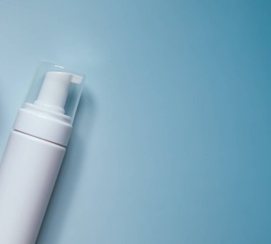 Açık mavi arka planı olan beyaz köpük şeker kutusu, güzellik, cilt bakımı ve kişisel hijyen ürünlerini temsil ediyor.