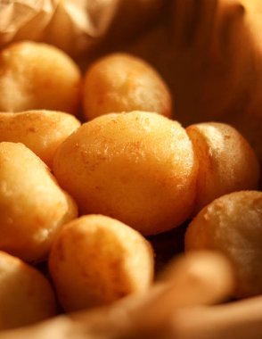 Pao de queijo, sıcak geleneksel Brezilya peynirli ekmek, taze ve yemeye hazır, kağıt torbada servis edilir.