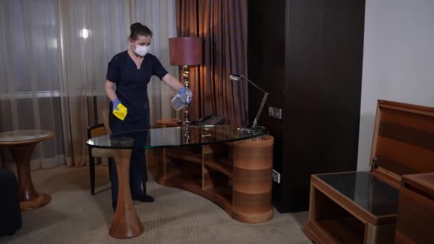 Kamermeisje schoonmaken salontafel in hotelkamer — Stockvideo