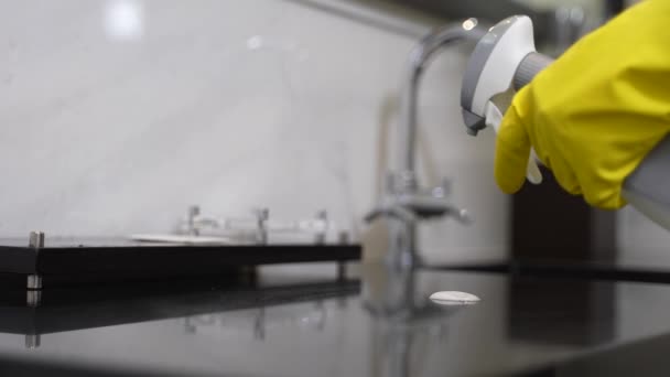 Mãos enluvadas desinfectando a superfície do lavatório no banheiro — Vídeo de Stock