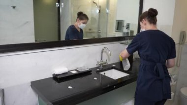 Otel çalışanları banyoda dezenfekte yapıyor.