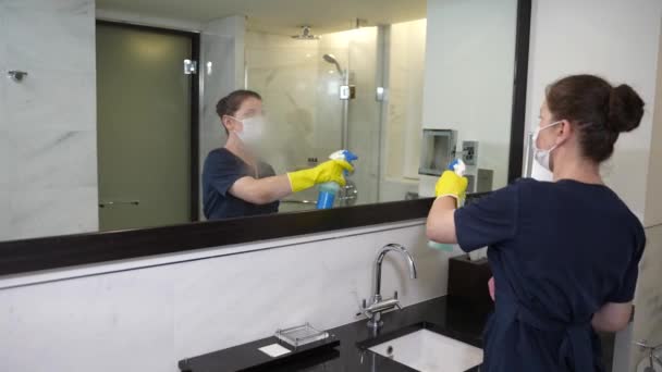 Маска покоївка обприскування і протирання дзеркала ванної кімнати — стокове відео