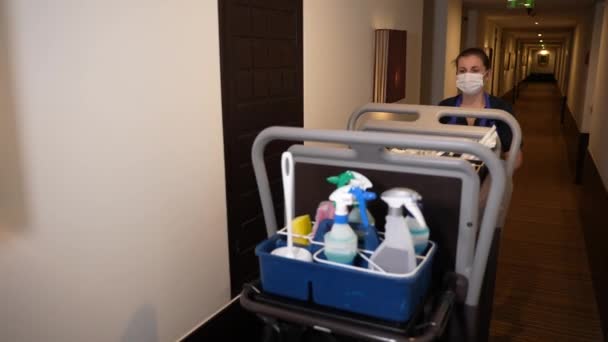 Pokojówka z wózkiem spacerującym korytarzem hotelowym — Wideo stockowe