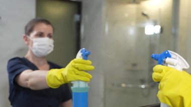 Hizmetçi iş sırasında banyo aynasına yansıyor.