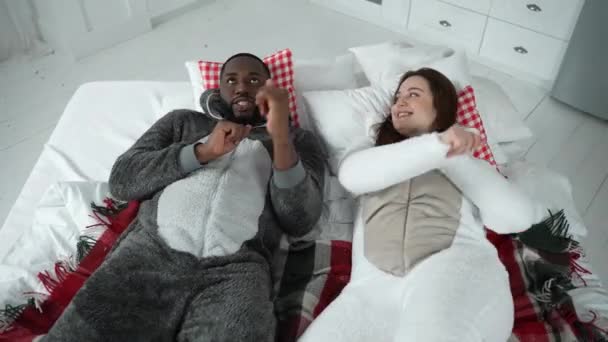 Positive couple in pajamas dancing lying on bed — Stock Video