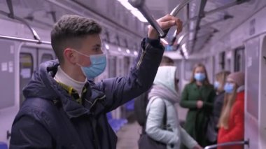 Yüzü maskeli genç bir adam toplu taşıma aracında.