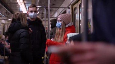 Bir grup maskeli insan yeraltı vagonunda