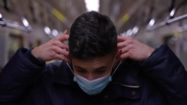 Joven vistiéndose de máscara protectora en metro — Vídeos de Stock