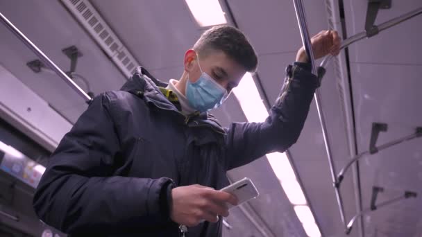 Zajęty na telefon zamaskowany nastolatek chłopiec jazda w metro samochód — Wideo stockowe