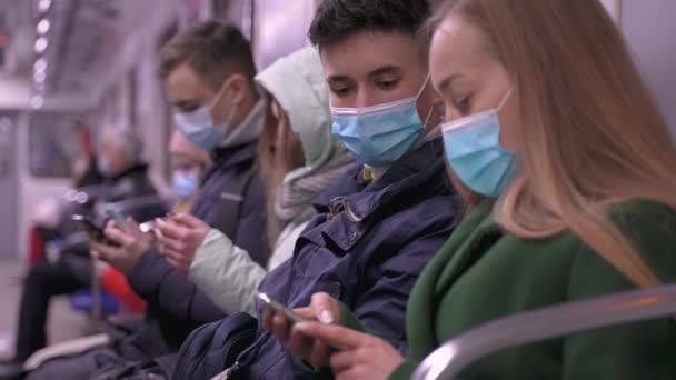 Maszkos metró utasok telefonnal a közlekedésben — Stock videók