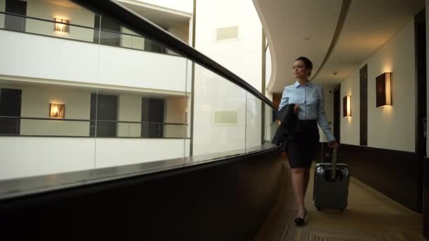 Donna sicura di sé passeggiando lungo il balcone interno dell'hotel — Video Stock