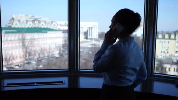 Empresaria contestando llamada telefónica por ventana del hotel — Vídeo de stock