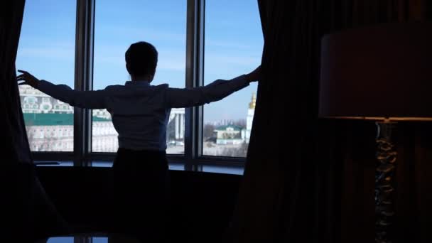 Silhouette nő élvezi a kilátást a hotel ablakában — Stock videók