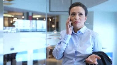 Telefoncu kadın otel asansörüyle yukarı çıkıyor.