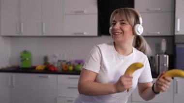 Mutfakta muzla dans eden mutlu kadın.