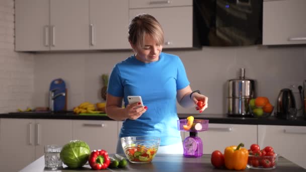 Mulher emagrecimento pesando legumes na cozinha — Vídeo de Stock