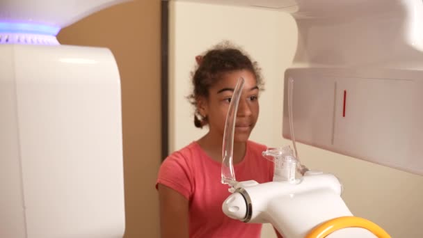 Preteen girl taking dental x-ray in modern clinic — Stockvideo