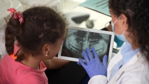 Dentista e criança paciente olhando para raio-X dental — Vídeo de Stock