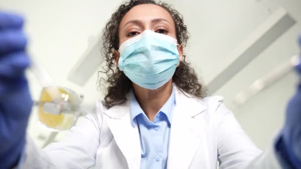 Mujer dentista inclinada sobre paciente para examen — Vídeos de Stock