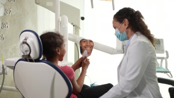 Menina sorridente admirando própria reflexão no dentista — Vídeo de Stock