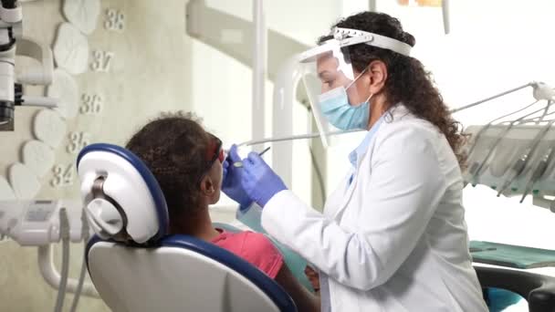Stomatologe bohrt Zahn eines Kinderpatienten — Stockvideo