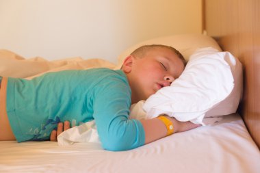 bir otel odasında uyuyan çocuk