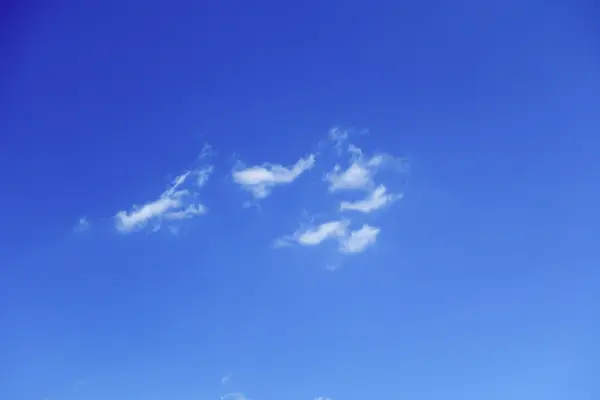 De witte wolken drijvend op een achtergrond van blauwe hemel — Stockfoto