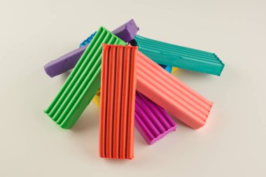 Çocuklar beyaz arka planda izole edilmiş yaratıcılık için mum plastiklerine renk katarlar