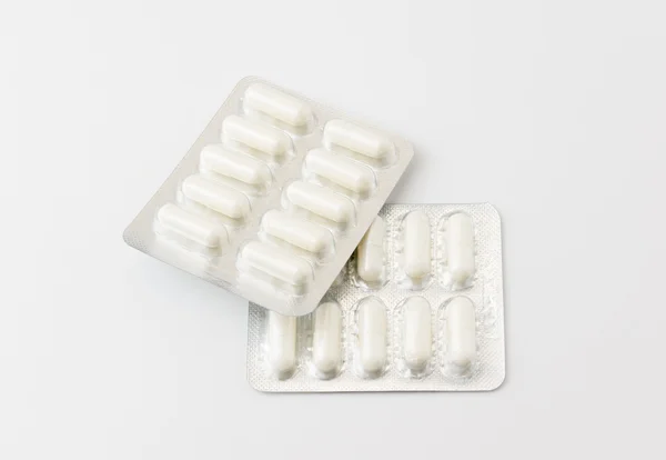 Белые таблетки и таблетки — стоковое фото