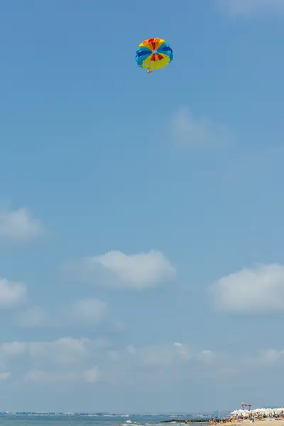 Paraquedas no céu sobre o mar — Fotografia de Stock