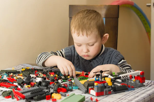 The boy at a table plays with the designer — Φωτογραφία Αρχείου