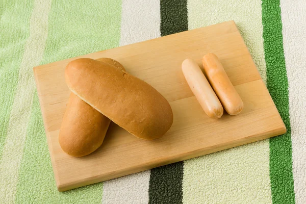 Sosis dan roti berbaring di papan — Stok Foto